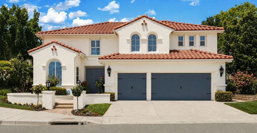 Elegant Spanish-style curb appeal with a tile roof, manicured landscaping, and a 3-car garage on a quiet Stevenson Ranch street.