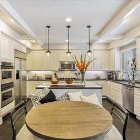 A chef-ready kitchen with stainless appliances, a beamed ceiling, and a sunny breakfast nook made for gathering. A chef-ready kitchen with stainless appliances, a beamed ceiling, and a sunny breakfast nook made for gathering.