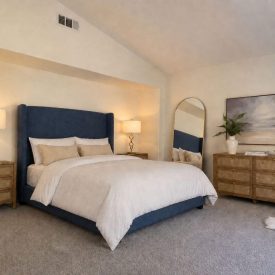 A serene primary suite with a vaulted alcove ceiling, plush carpet, and warm, curated furnishings for total relaxation. A serene primary suite with a vaulted alcove ceiling, plush carpet, and warm, curated furnishings for total relaxation.