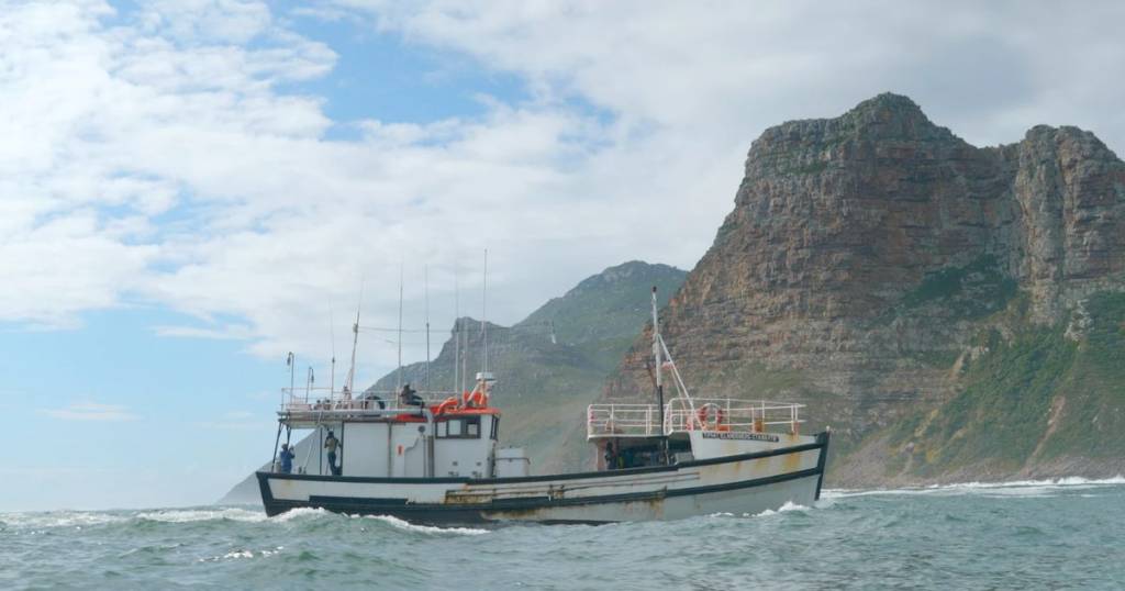 A fishing boat under the cliffs off Cape Town, filmed by Ayni Studios for Seafood Souq's film on pole-and-line tuna fishing and seafood traceability.